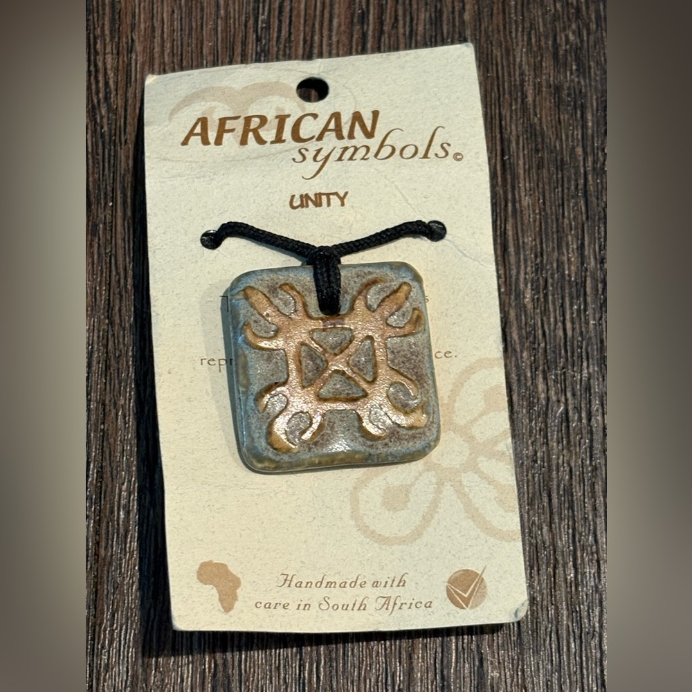 New, never worn African Symbols UNITY pendant on black rope necklace.